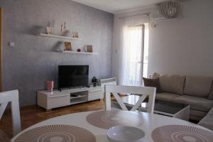 - un salon avec un canapé et une table dans l'établissement Lanai Apartment, à Trebinje