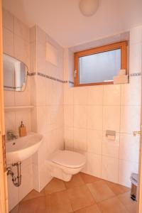 a white bathroom with a toilet and a sink at Chalet Obenland Kitzbüheler Alpen Suite in Bramberg am Wildkogel