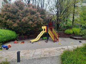 un parque infantil con tobogán y juguetes en un patio en High Class Residence Leopold en Budapest