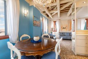 ヴェネツィアにあるFriari Suite-Luxury apt. close to Rialto Bridgeの木製のテーブルと白い椅子のあるダイニングルーム