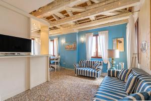 ヴェネツィアにあるFriari Suite-Luxury apt. close to Rialto Bridgeの青い壁のリビングルーム(ストライプのソファ付)