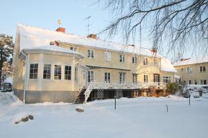 una casa grande en la nieve en el patio en Nynäsgården Hotell & Konferens en Nynäshamn