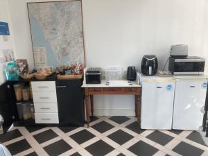 a kitchen with a desk with a microwave and a refrigerator at HH Accommodation in Millom