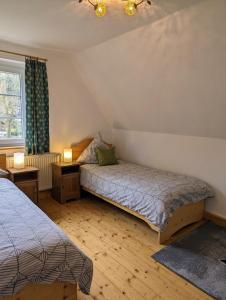 een slaapkamer met 2 bedden en een raam bij Landhaus Eilenberg Holzhau in Rechenberg-Bienenmühle