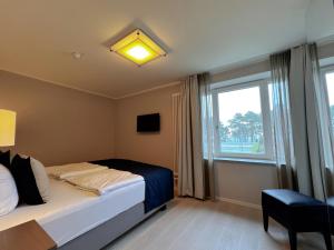 Schlafzimmer mit einem Bett und einem Fenster in der Unterkunft Prora Strand Appartement in Binz