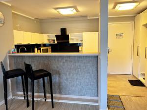 eine Küche mit zwei schwarzen Hockern an einer Bar in der Unterkunft Prora Strand Appartement in Binz