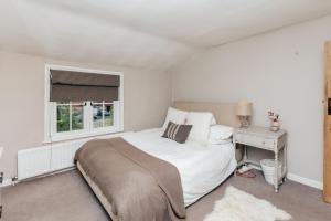 Soho House - 4 Bedrooms, Central Henley في هينلي على نهر التايمز: غرفة نوم بيضاء بها سرير ونافذة