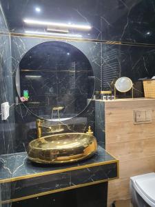 a bathroom with a gold sink on a counter at Apartament Dubaj in Gliwice