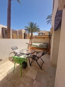 a patio with a table and chairs on a balcony at Nayah Stays, Beautiful 3-bedroom vacation home with lovely pool in Hurghada