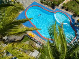 een uitzicht over een zwembad met palmbomen bij F-Zeen Boutique Hotel Zanzibar in Uroa