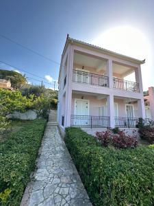 a white house with a walkway in front of it at Alexandra’s Studios Sunset View in Argostoli