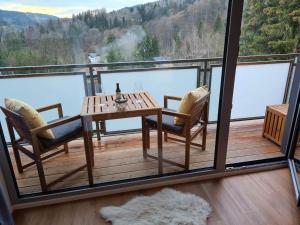 una mesa y sillas en un balcón con vistas al agua en Horský apartmán Stella en Janov nad Nisou