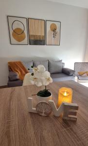 una sala de estar con una mesa con una flor y una vela en LuengiHouse - Espectacular apartamento con piscina, en Lloret de Mar