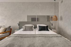a bedroom with a large bed with three pillows at GRANO HOTEL Solmarina in Wiślinka