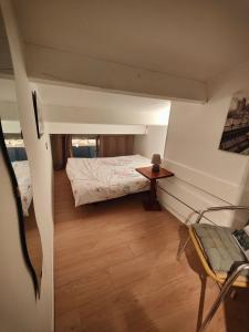 a room with a bed and a table and a chair at Appartement 3 chambres Quartier des Falaises Le Cap d'Agde in Cap d'Agde