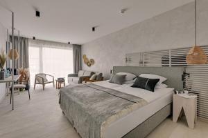 a bedroom with a large bed and a living room at GRANO HOTEL Solmarina in Wiślinka