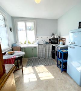 cocina con nevera y mesa. en Maison Collinée, en Rostrenen