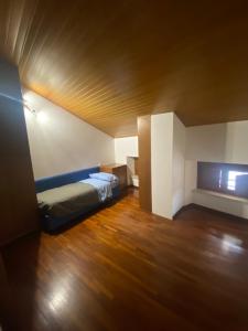 a small room with a bed and a wooden floor at Attico in centro in Udine