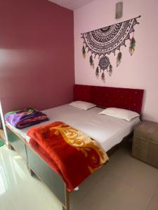 a small bedroom with a bed with a red headboard at Banaras Guest House in Varanasi