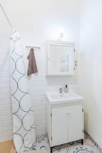 uma casa de banho branca com um lavatório e um espelho em Nature Studio em Budapeste