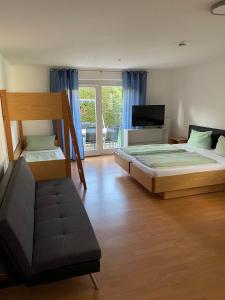 a bedroom with two beds and a couch and a television at Apartment FIVE - EP Ticket Garantie in Rust