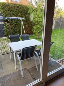a white table and chairs in front of a window at Apartment FIVE - EP Ticket Garantie in Rust