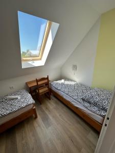 dwa łóżka w pokoju z oknem w obiekcie Hangulatos Balaton parti nyaraló w mieście Révfülöp