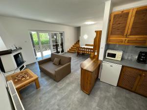 eine Küche und ein Wohnzimmer mit einem Sofa und einem Tisch in der Unterkunft Hangulatos Balaton parti nyaraló in Révfülöp