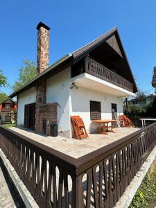 Casa con terraza con mesa y sillas en Hangulatos Balaton parti nyaraló, en Révfülöp