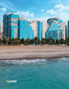 uma praia com alguns edifícios azuis ao fundo em Apartment on Khimshiashvili 1 em Batumi