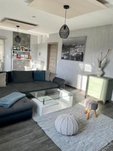 un soggiorno con divano e tavolo in vetro di Maintal Relax a Michelau
