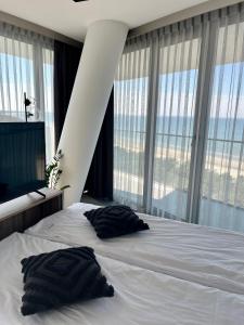 1 dormitorio con 1 cama con 2 almohadas en AXEL WAVE Seaview Apartment &SPA, en Międzyzdroje