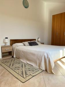 een slaapkamer met een groot bed en een houten kast bij Residenza "SINIS" in Càbras