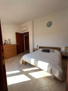 een slaapkamer met een bed in een witte kamer bij Residenza "SINIS" in Càbras