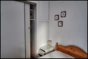 a small bedroom with a bed and a refrigerator at Le plongeoir in Saint-Trojan-les-Bains