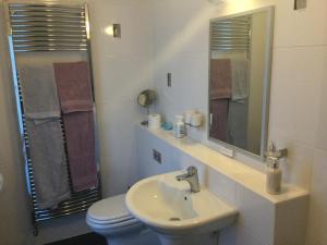 een badkamer met een wastafel, een toilet en een spiegel bij HH Accommodation in Millom +20 foto's