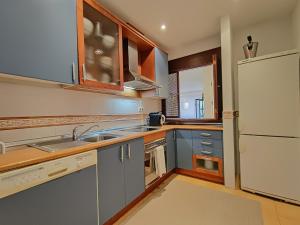 uma cozinha com armários azuis e um frigorífico branco em Oasis 3 bedroom Marbella Golden Mile em Marbella