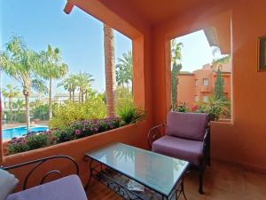 a balcony with a table and a chair and a pool at Oasis 3 bedroom Marbella Golden Mile in Marbella