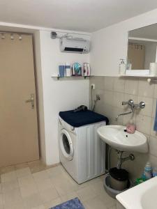 a bathroom with a washing machine and a sink at Cultural monument House Vecchia in Otočac