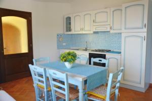 聖瑪麗亞納瓦雷的住宿－Mandorlo 5，一间带桌椅的厨房和一间带白色橱柜的厨房