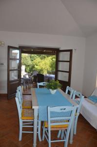 a dining room with a blue table and chairs at Mandorlo 5 in Santa Maria Navarrese