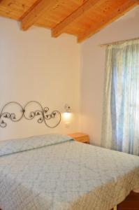 a bedroom with a bed and a window at Mandorlo 5 in Santa Maria Navarrese