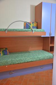 two bunk beds in a room with green sheets at Mandorlo 5 in Santa Maria Navarrese