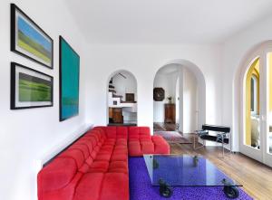 a living room with a red couch and a table at Villa Ella in Luxury Resort in Gardone Riviera