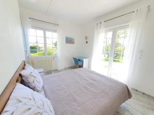una camera bianca con un letto e due finestre di Logement entier avec grand jardin et parking WIFI 6 et Fibre a Berck-sur-Mer