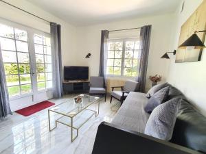un soggiorno con divano e TV di Logement entier avec grand jardin et parking WIFI 6 et Fibre a Berck-sur-Mer