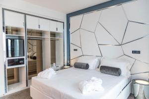 a bedroom with a white bed with towels on it at The Promenade Luxury Wellness Hotel in Riccione