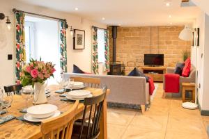 a dining room with a table and a living room at Stainsborough Hall Holiday Cottages in Wirksworth