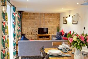 a living room with a couch and a table at Stainsborough Hall Holiday Cottages in Wirksworth