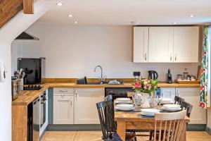 a kitchen with a table with chairs and a sink at Stainsborough Hall Holiday Cottages in Wirksworth